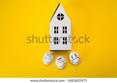 drawing faces on eggs and carton house isolated on yellow background