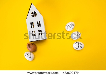 drawing faces on eggs and carton house isolated on yellow background