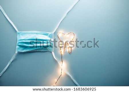 Tooth symbol with led light strip and surgical mask of a doctor. Dentist concept.