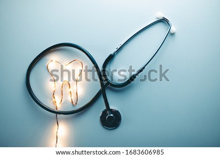 Tooth symbol and medical stethoscope. Stylized dentist concept.