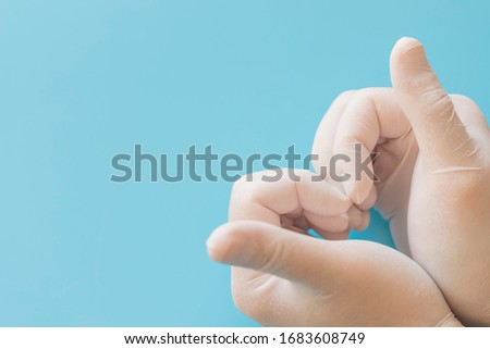 Hands in medical gloves making heart.