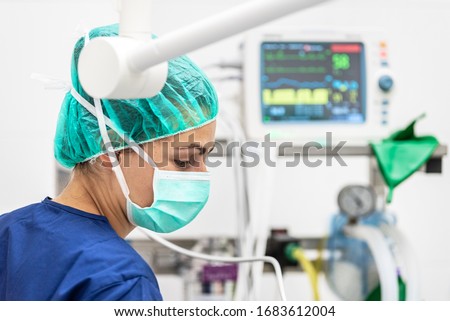 Covid-19 outbreak. Healthcare worker. Nurse working in intensive care unit. Mechanical ventilation system in the background . Royalty-Free Stock Photo #1683612004