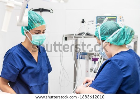 Covid-19 outbreak. Healthcare worker. Nurse working in intensive care unit. Mechanical ventilation system in the background . Royalty-Free Stock Photo #1683612010