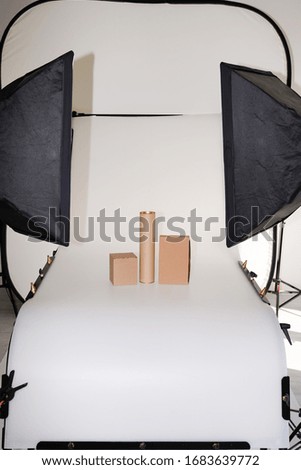 Photo studio with professional lighting equipment during shooting object brown empty boxes