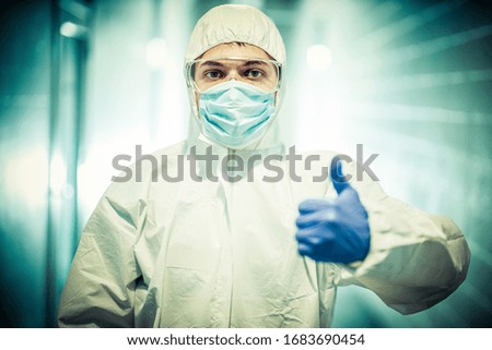 corona virus concept. male scientist doctor in mask, glasses and protective suit showing thumb up