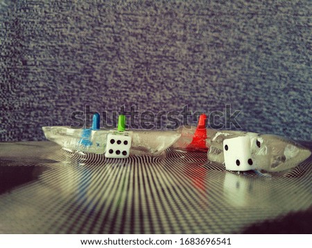 playing blocks and chips frozen in melting pieces of ice on a dark gray background in a creative and abstract macro photo
