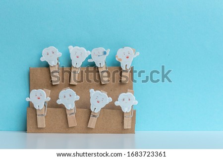 Clothes pegs with wooden teeth on blue background.  Free space for text. Conceptual image. 