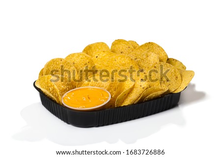 Black plastic tray of round yellow nachos with melted cheese dip on white background isolated Royalty-Free Stock Photo #1683726886