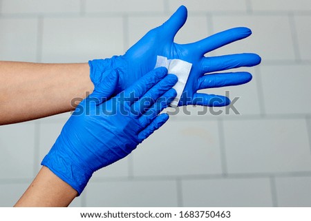 hands in blue medical gloves