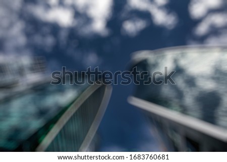 Abstract business modern city urban futuristic architecture background. Real estate concept, motion blur, reflection in glass of high rise skyscraper facade, toned blue picture with bokeh