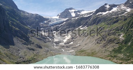 A view of a lake filled with water from the melted snow of the mountains.