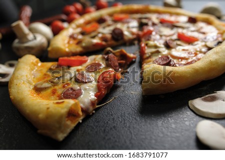 big bright tasty juicy pizza on black background. blue onions. cherry tomatoes. champignons.
