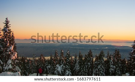 Sunset above the clouds at beautiful British Columbia. Picture taken from Grouse Mountain showing the city of Vancouver in the background in a stunning winter sunset