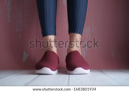 Legs of beautiful woman in stylish shoes on color background.