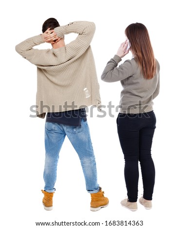 Back view of couple in sweater with mobile phone. beautiful friendly girl and guy together. Rear view people collection. backside view of person. Isolated over white background.