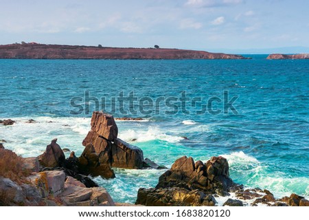 seascape with rocks and cliffs. beautiful scenery in the afternoon light. island in the distance. fluffy clouds on the evening sky. st. Ivan and st. Peter island of bulgaria in the distance