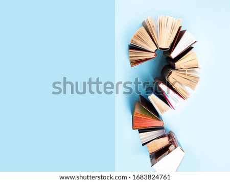 old books on blue background, flat lay with copy space