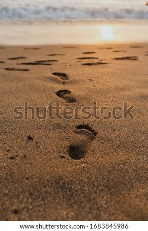 
Footprints in the sand on a Balinese beach during sunset