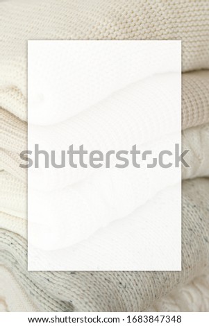 Stock Photo - Stack of cozy knitted sweaters with blank business card. For design presentations and portfolios.