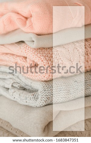 Stock Photo - Stack of cozy knitted sweaters with blank business card. For design presentations and portfolios.