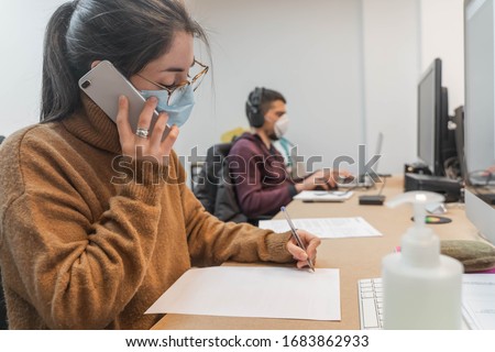 Coronavirus. Business workers working from home wearing protective mask. Small company in quarantine for coronavirus working from home with sanitizer gel. Small company concept. Royalty-Free Stock Photo #1683862933