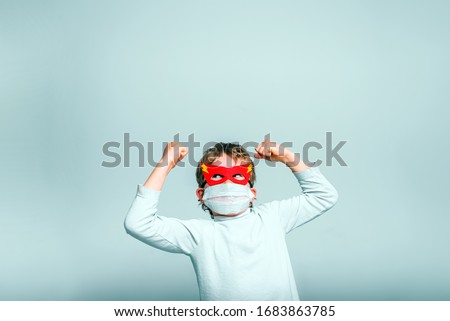 A boy with a fun superhero mask to protect himself from the viral infections of the disease.