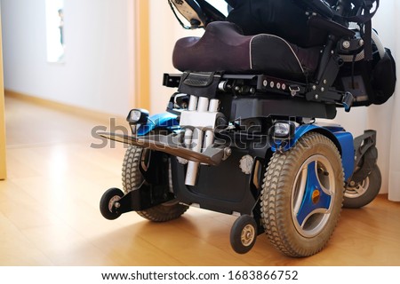 Blue electric wheelchair for disabled people - indoors Royalty-Free Stock Photo #1683866752