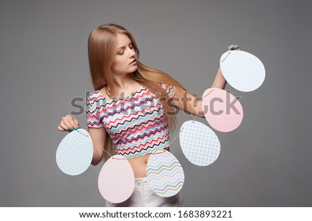 Smiling girl holding a banner of Easter eggs shape