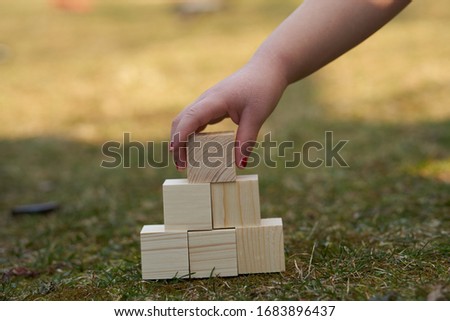 Child stacking wooden blocks in a tower or pyramid shape