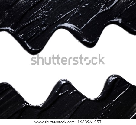 Smear of a black magnetic or charcoal mask on a white isolated background. Smudge texture brush waves frame.