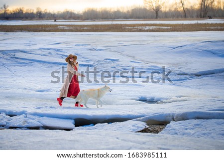 A woman on a walk with a dog in winter