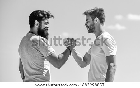 Strong and muscular arms. Successful deal handshake blue sky background. Men shaking hands at meeting. Friendly handshake gesture concept. Friends or competitor. Handshake arm wrestling style.
