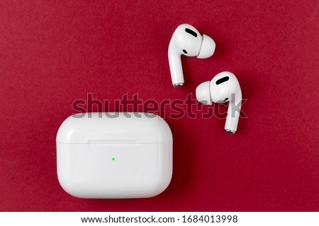 Air Pods Pro. with Wireless Charging Case. New Airpods pro on red background. Airpods Pro. Copy space Royalty-Free Stock Photo #1684013998