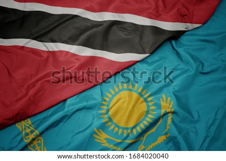 waving colorful flag of kazakhstan and national flag of trinidad and tobago. macro