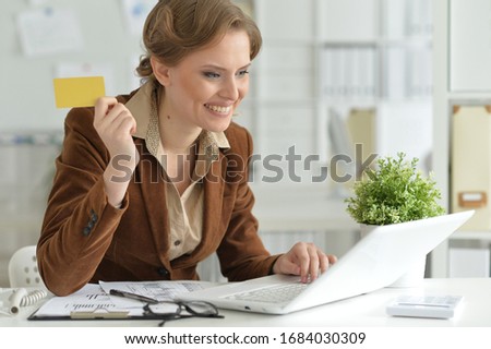Portrait of a cute young businesswoman holding credit card