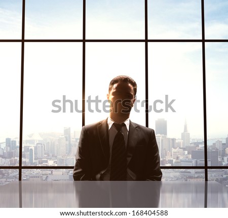 young businessman sitting on table in office