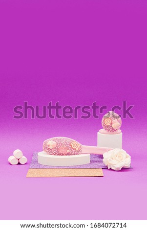 Shiny hair brush and decorated mirror on a shiny purple and yellow background
