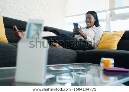 Black Woman Using Portable Wi-Fi Printer For Printing Pictures