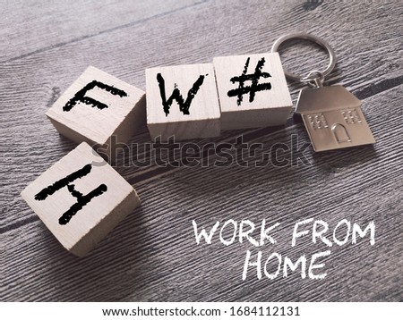 concept image a wooden block and word - #WFH ( WORK FROM HOME ) over wooden background/key chain with selective focus.
