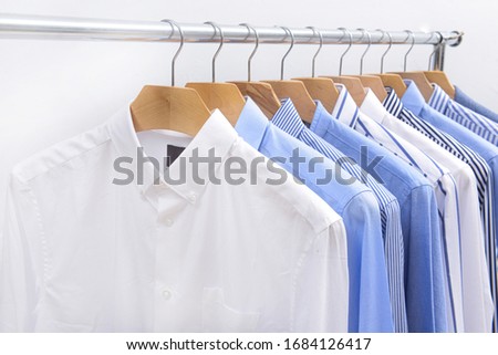 Row of fashion new men's blue and white ,striped long sleeve shirts on hanger -white background