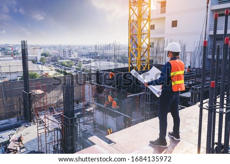 Smart civil architect engineer inspecting and working outdoors building side with blueprints. engineering and architecture concept. Royalty-Free Stock Photo #1684135972