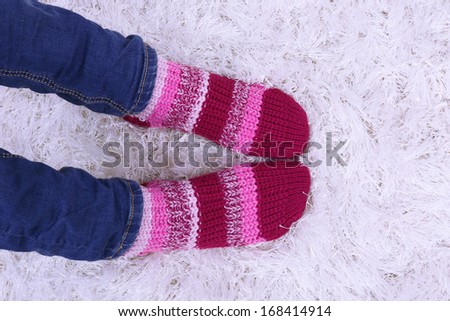 Female legs and  colorful socks on white carpet background