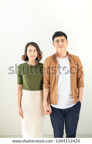 Portrait Of Happy Young Loving Couple Looking At Camera Isolated On White Background
