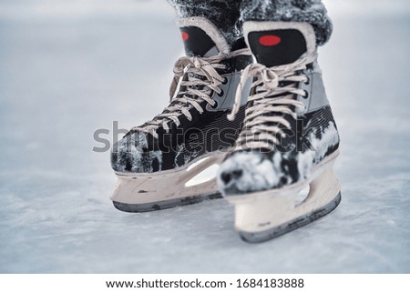Hockey skates on the player feet after ice hockey. Close-up