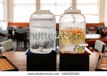 Photo of two water jugs in a dinning room, lemon water