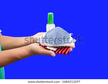 mask fabric prophylaxis virus homemade pile and bottle gel alcohol on hand over blue background. prevent coronavirus or (Covid-2019) concept