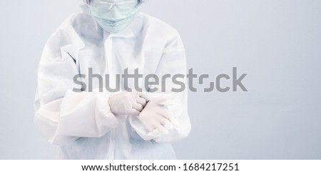 Asian female doctor, wearing personal protective suit or PPE, goggle, mask, and gloves, prepare to take care of coronavirus infected patients during covid-19 outbreak. Medical and covid19 concept. Royalty-Free Stock Photo #1684217251