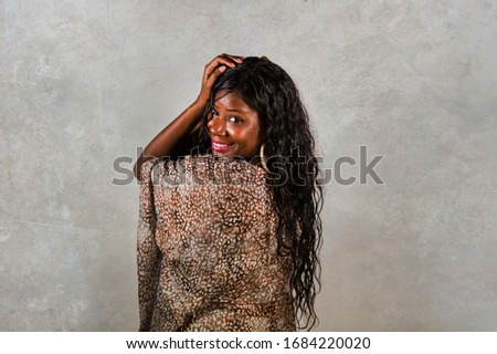 young stylish and happy black African American woman posing confident and playful isolated on grunge background looking at camera in cool and positive attitude smiling cheerful