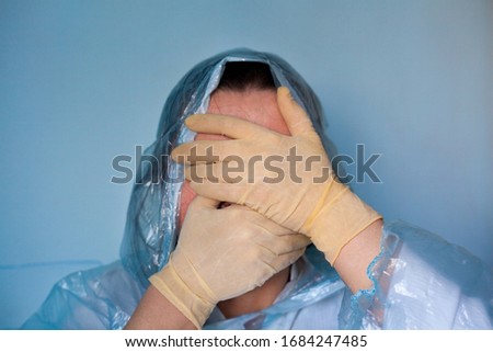 Woman in a protective suit closing her face. Distressed woman. Coronavirus (Covid-19) disease outbreak.  Royalty-Free Stock Photo #1684247485