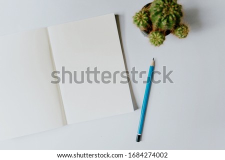Top view open notebook, pencil and plant potted on white desk background , copy space. -vintage style picture and vintage color